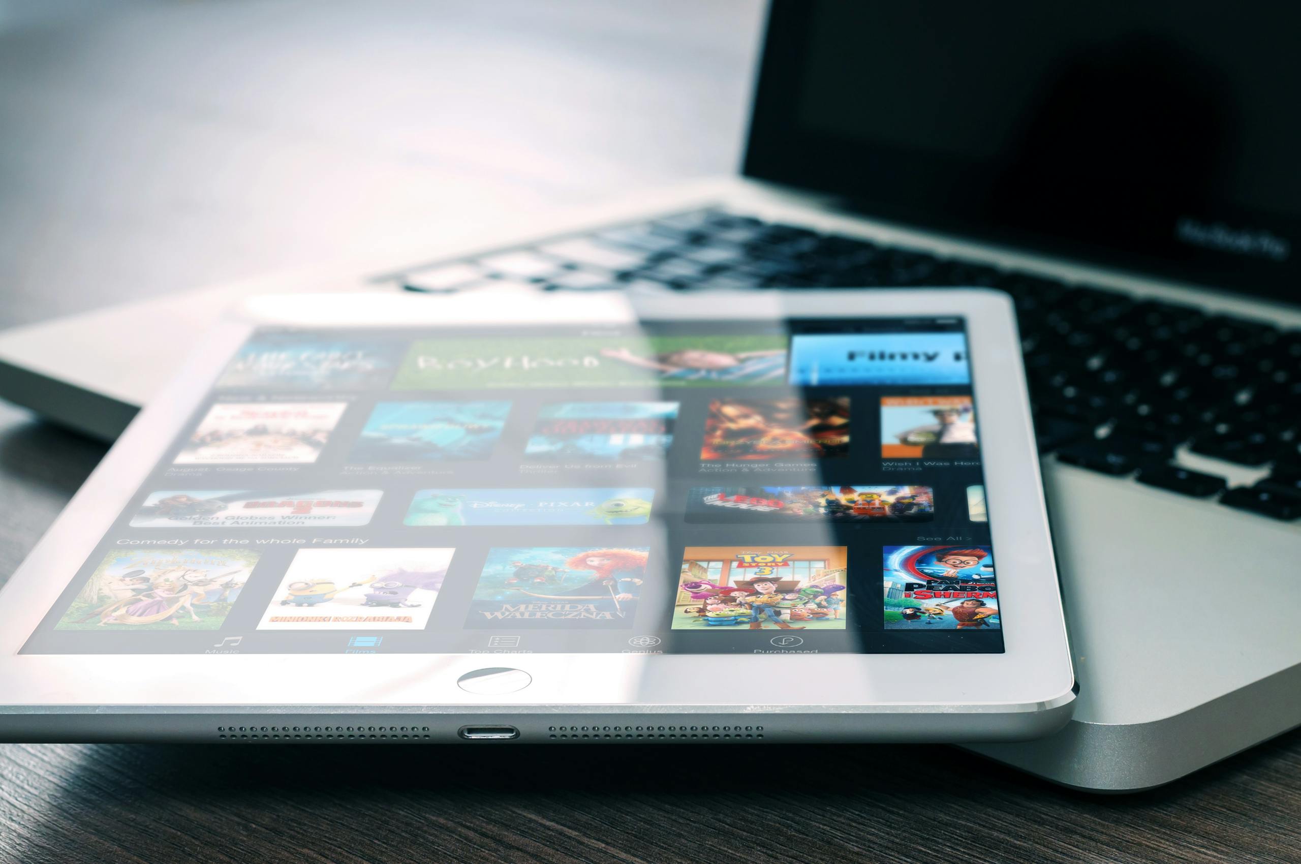 Tablet displaying streaming services on a laptop, illustrating digital entertainment setup.